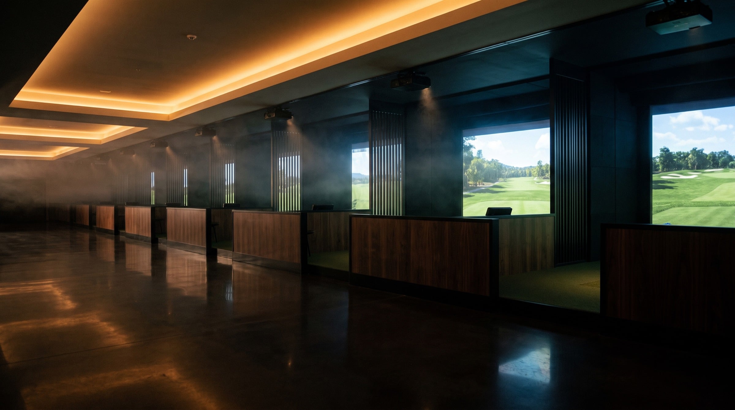 A row of lit indoor golf simulator bays receding in perspective.